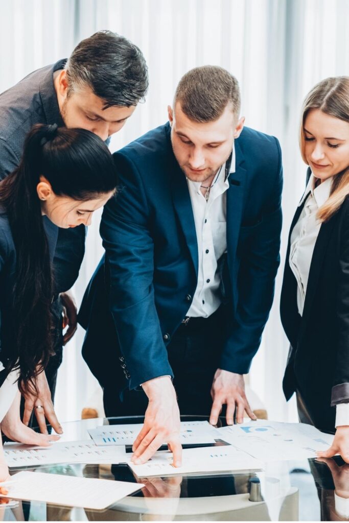 führungskräftetraining in sachsen in thüringen mit einem dozenten - 4 personen schauen sich das unterrichtsmaterial an